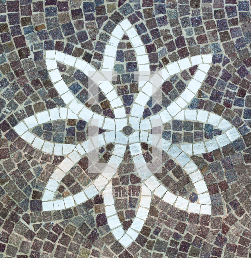 Paving with cobble stones and flower shaped design made with cubes of marble.