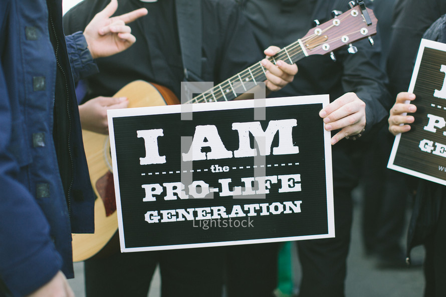 supporters at a pro life march gather to sing and pray before the event