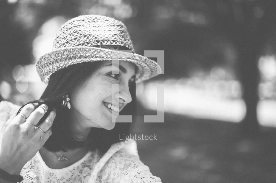 side profile of a woman in a straw hat outdoors 
