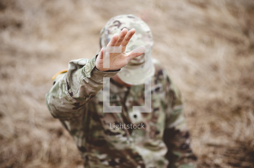 soldier with hand raised 