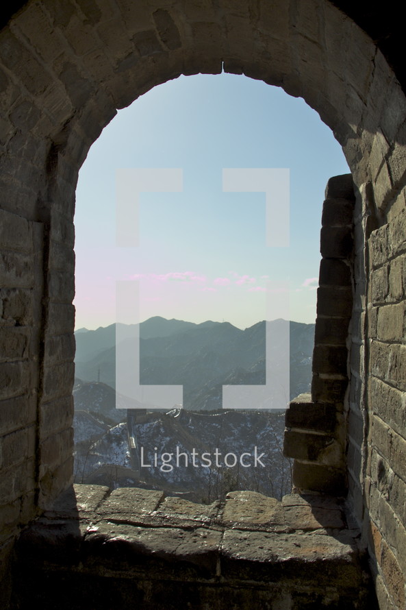 looking out a window at a mountain view from the Great Wall