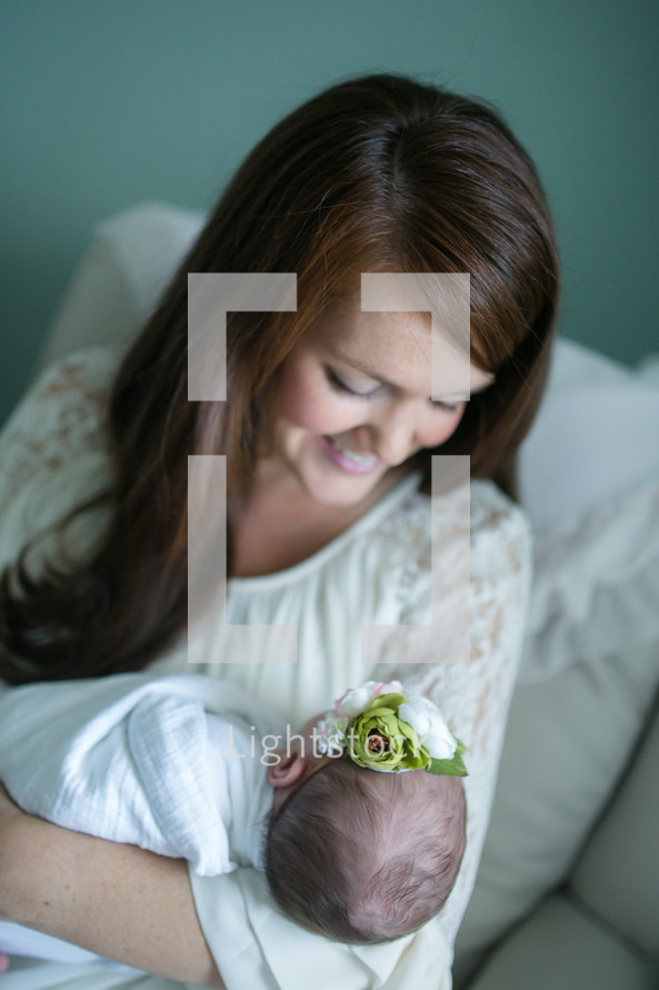 mother with a swaddled newborn baby girl 