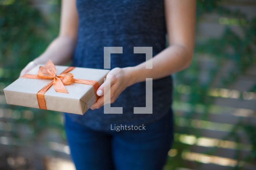 a woman holding a wrapped gift 