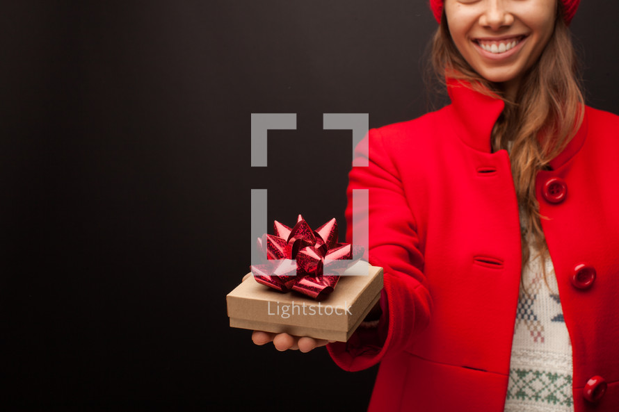 a woman giving a wrapped present 