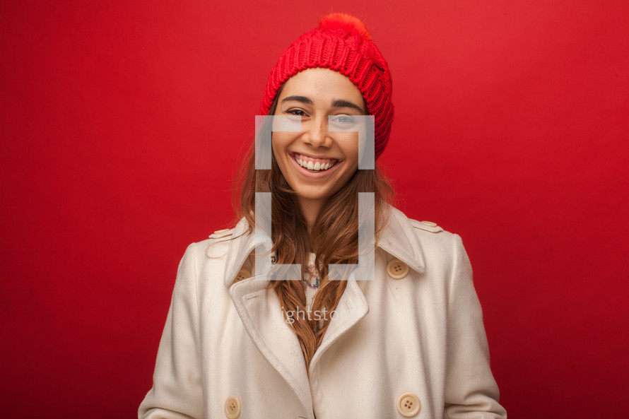 a woman in a winter coat and hat smiling 