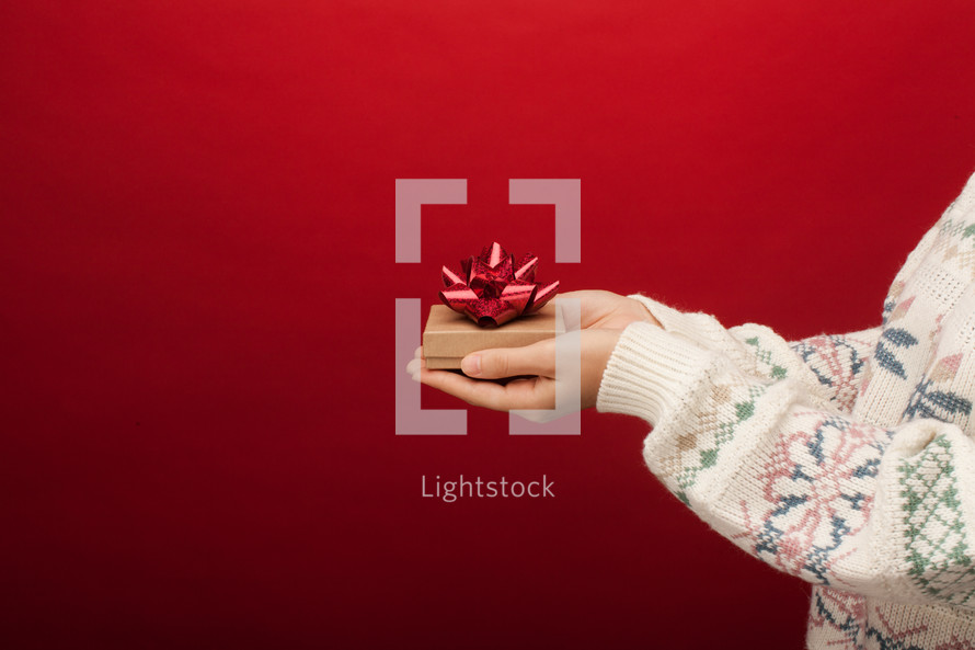 cupped hands holding a gift box 