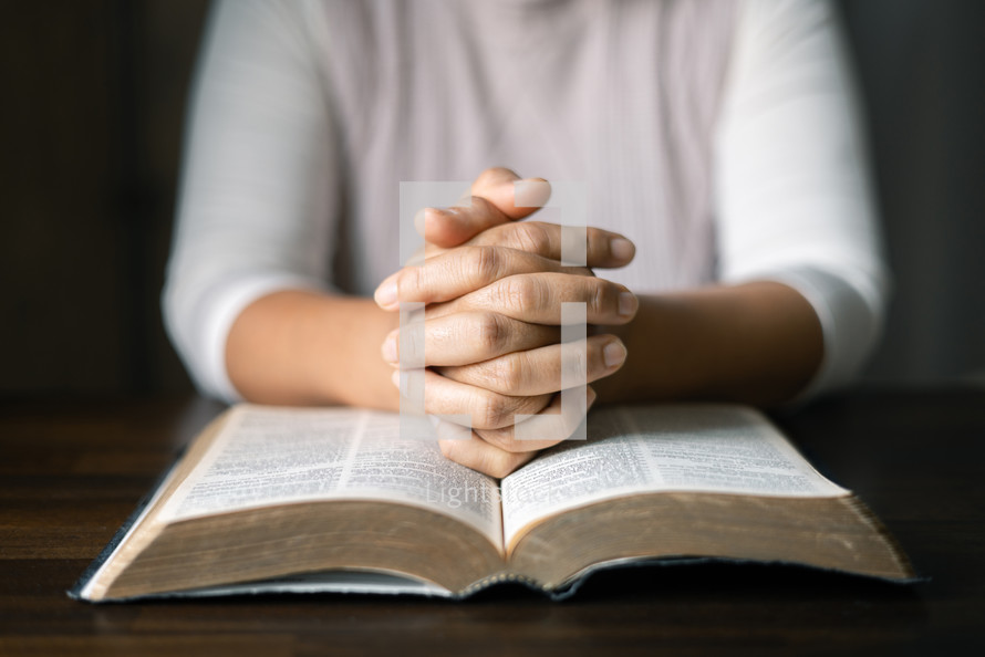 Close up of hands and a Bible