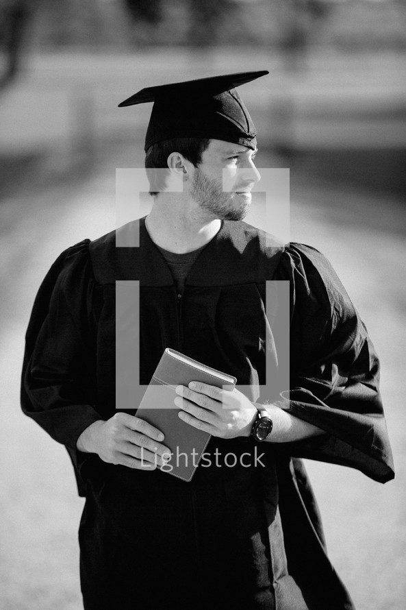 college graduate holding a Bible