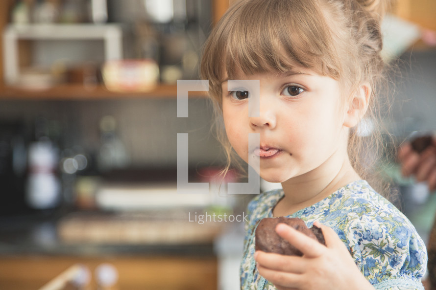 toddler girl eating a muffin 