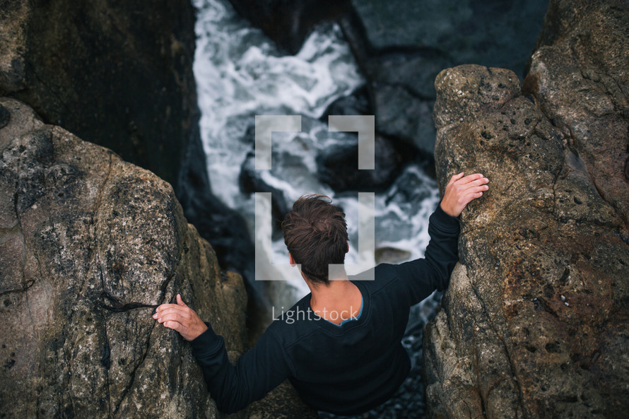 a man standing between rocks on a shore in Tasmania 