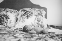 a newborn baby sleeping on a bed 