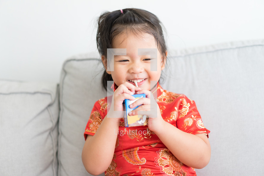 a toddler drinking a juice box 