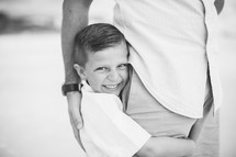 son hugging his dad's leg