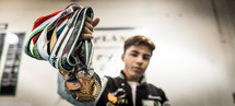 a teen boy with lots of medals 
