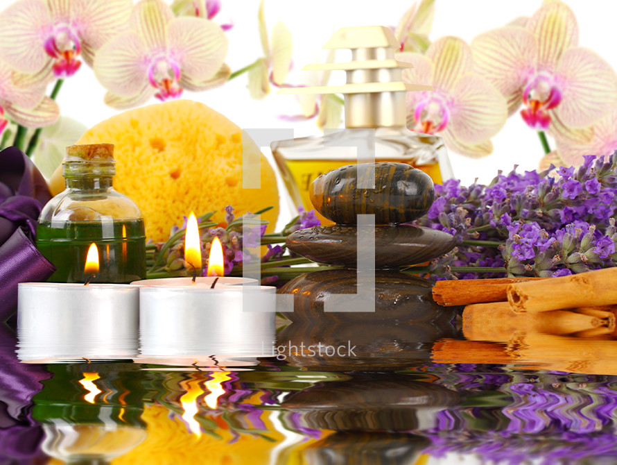 Accessories for spa with orchids, lavender, stones, sponge, candles and cinnamon.