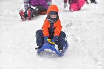 kid sledding in snow 