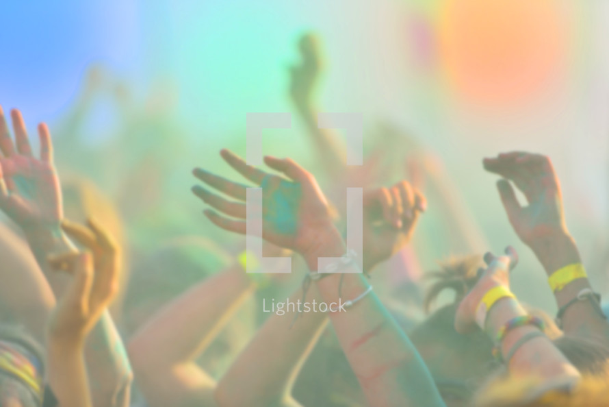 Defocused image of close-up with peoples hands on running marathon, people covered with colored powder.