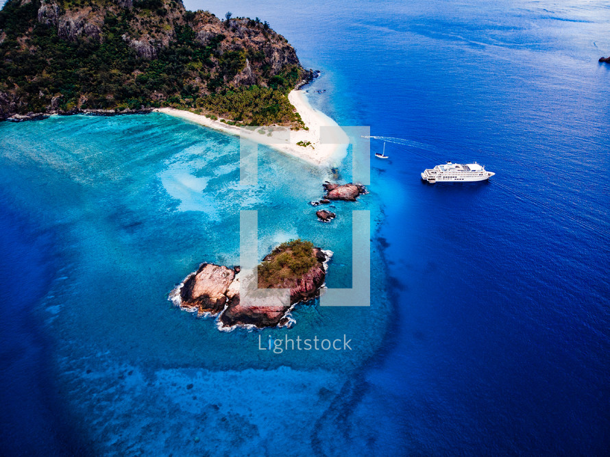 aerial view over a blue sea and cruise ship 
