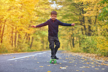 boy riding skateboard outdoors in autumn environment on sunset warm light