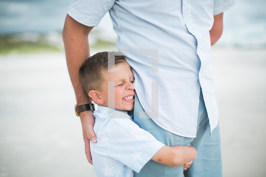 a son hugging his dad's leg