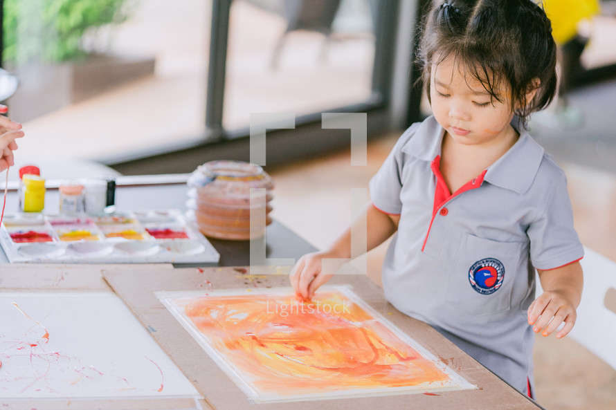 a toddler girl painting 