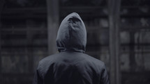 man in a hoodie with his back to the camera 