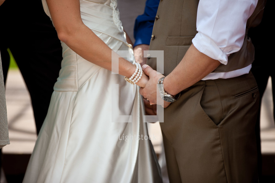 Bride and groom holding hands.