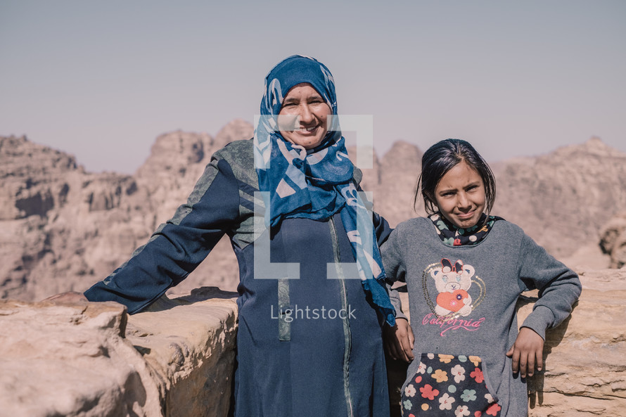 mother and daughter standing in a desert 