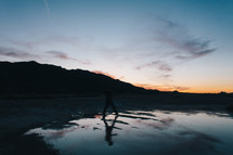 a man standing in a lake at sunset 