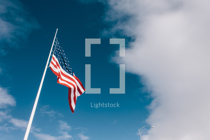 American flag on a flag pole against a blue sky 