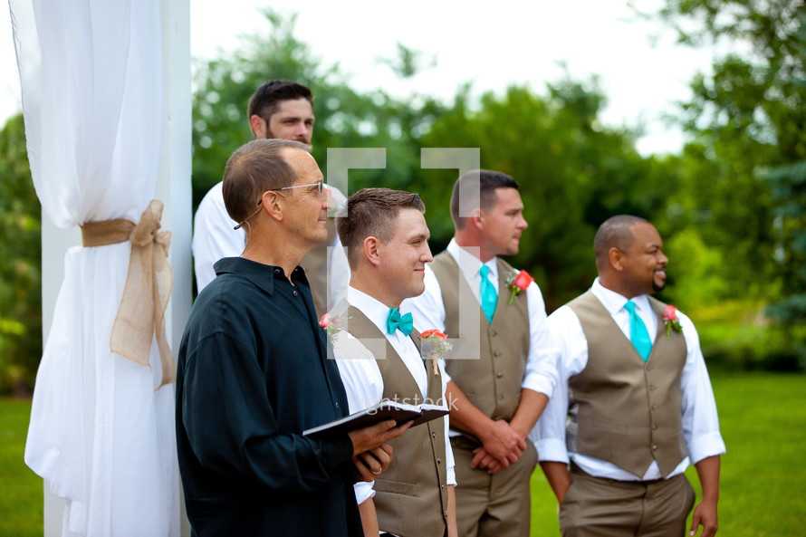 groomsmen standing next to the minister 