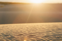 sunlight shining on ripples in sand