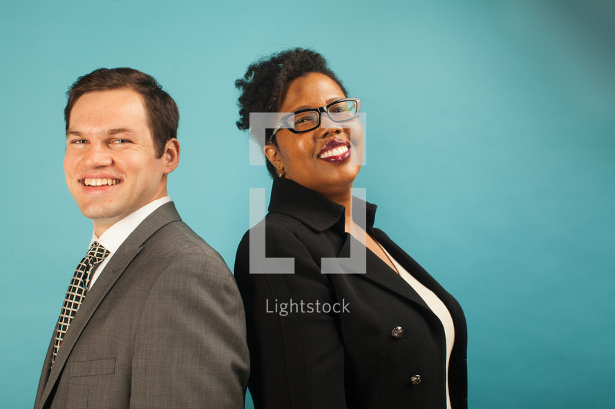 businessman and businesswoman standing back to back 