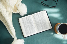knit beanie, glasses, open Bible, and mug 