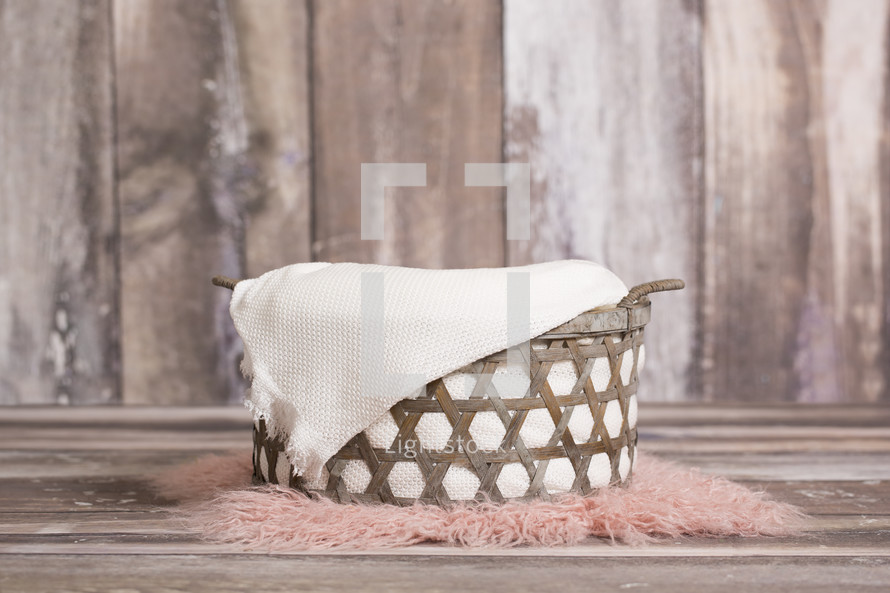 basket on a pink fur rug 