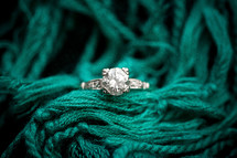 engagement ring on a turquoise scarf