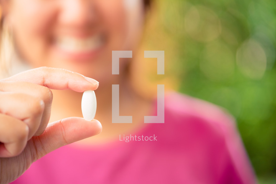 a woman holding a pill 