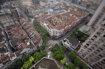 aerial view above rooftops in a city below 