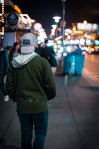 a man walking down a sidewalk at night 