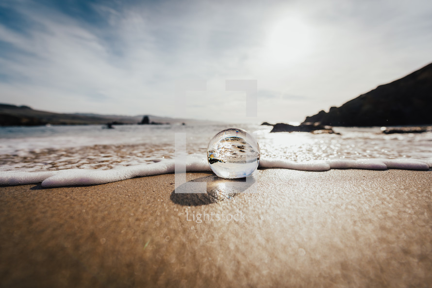 glass orb on a beach 