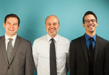 businessmen standing in front of a blue background 