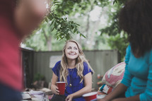 friends holding cups and in conversation at a cookout 