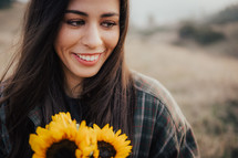 a woman holding a bouquet of sunflowers 