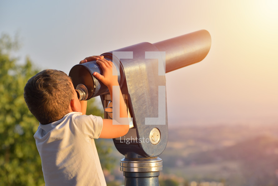 kid looking though a Tourist telescope eyepiece. Travel tourist destination landscape magnification