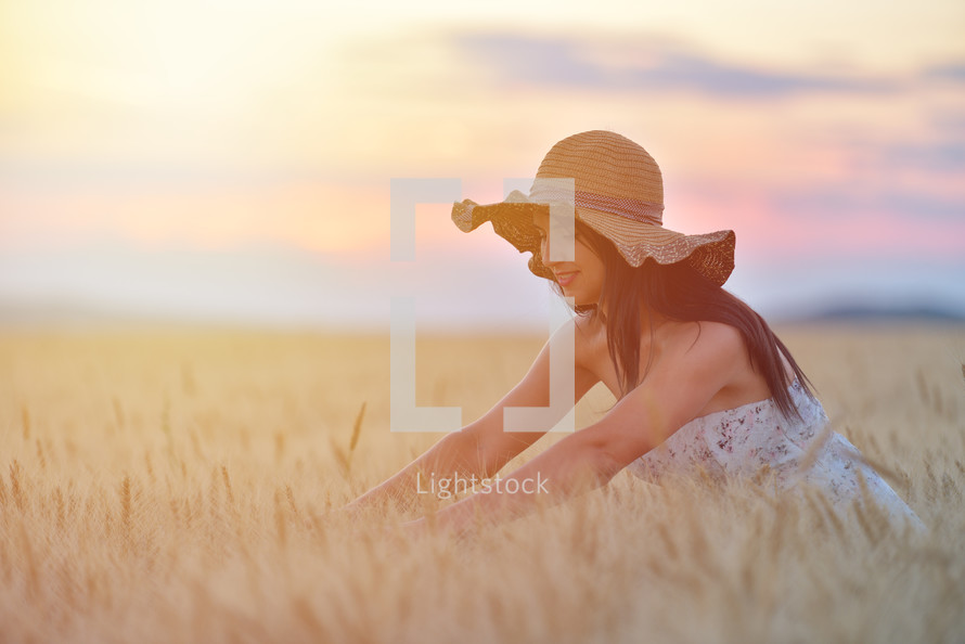 woman standing in a golden wheat field 