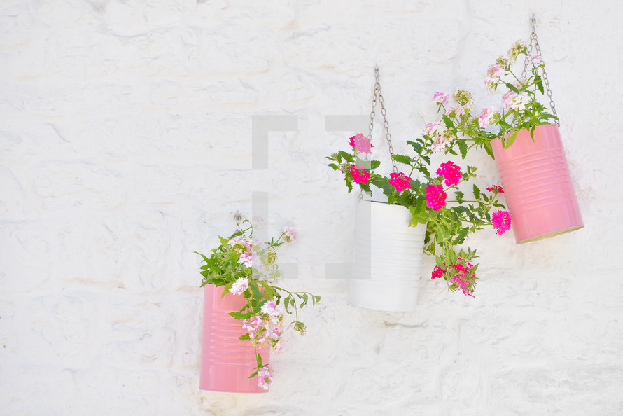 Flowers and baskets against white painted brick wall in Alberobello italy