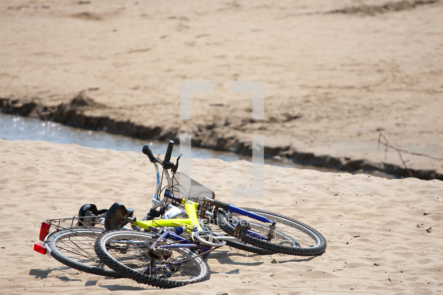 Two old bikes on the beach.