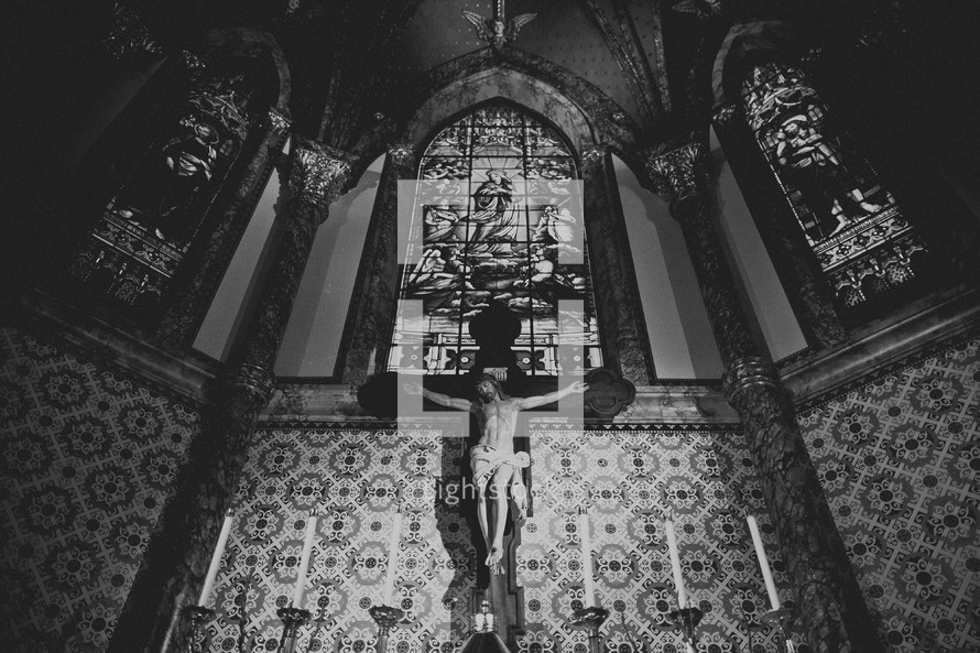 A large crucifix hanging  in a tall sanctuary