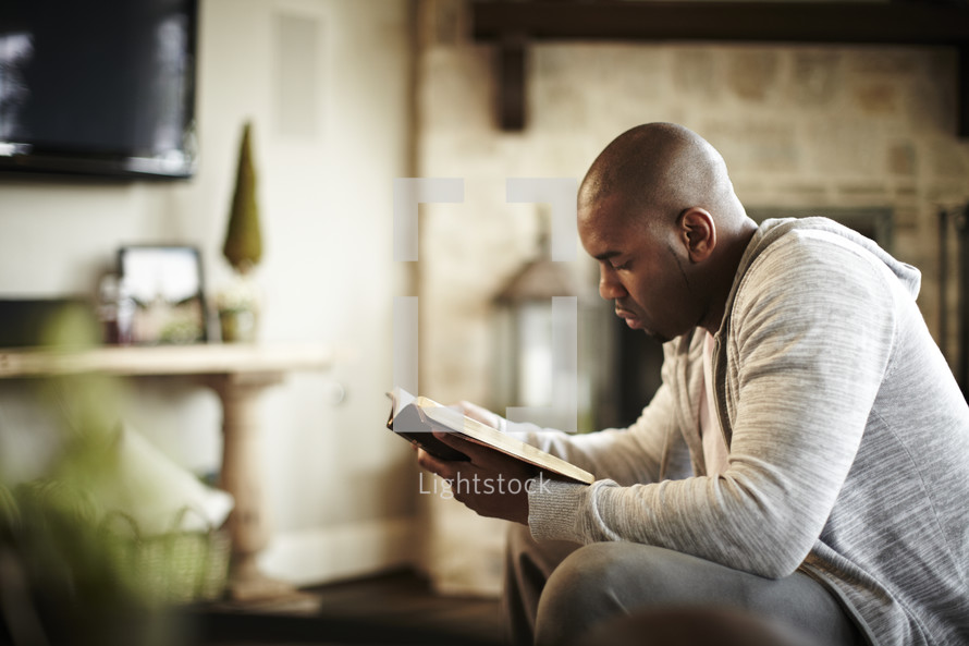 An African American man reads the Bible during his quiet time