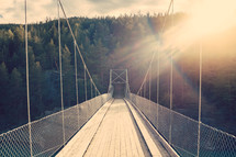 rays of sunlight shining on a footbridge 